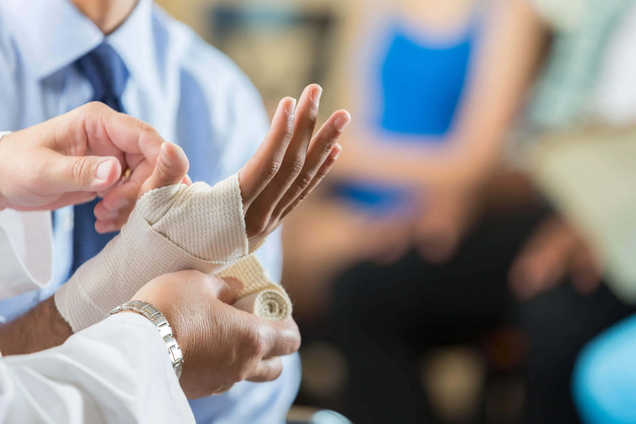 man in a suit getting a bandage on his hand