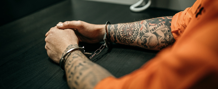 Prisoner in handcuffs sitting in an interrogation room
