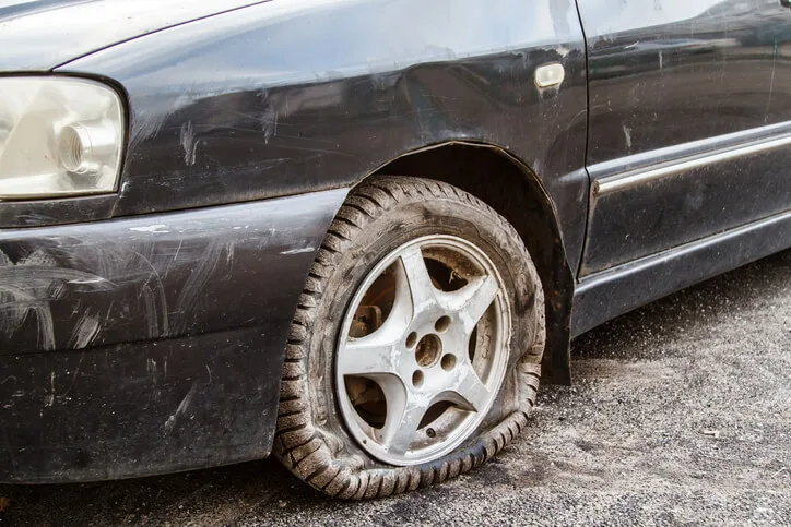 Car with a flat as a result of road damage