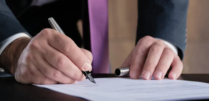 Expert witness signing a piece of paper