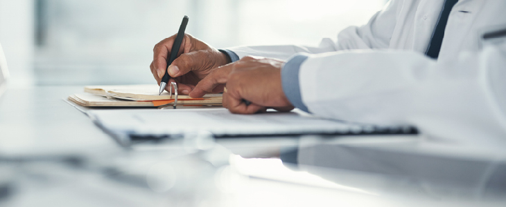 Doctor signing a medical form