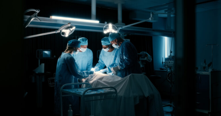 Operation room, doctors and trust with night surgery, teamwork and healthcare for emergency in hospital. Group, employees and collaboration in surgical room, skills and medicare clinic with trust